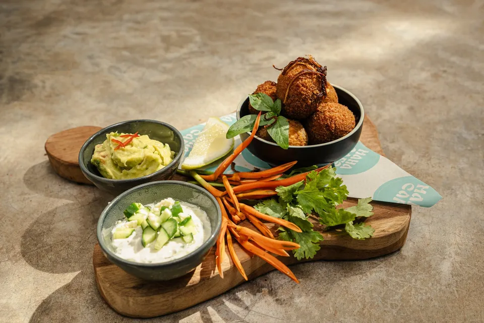 Falafel with guacamole and tzatziki on a board at Maha Mezze